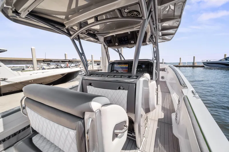 Slide: The Image of 2021 Nor-Tech 390 Sport Center Console boat interior at marina, featuring sleek seating and modern design. - 6