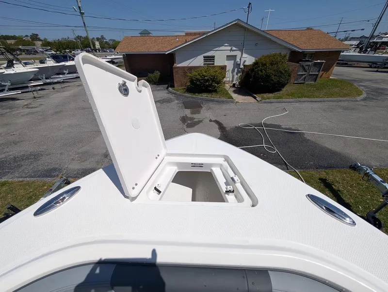 Slide: The Image of 2025 Robalo R232 Explorer boat with open storage compartment on deck. - 14