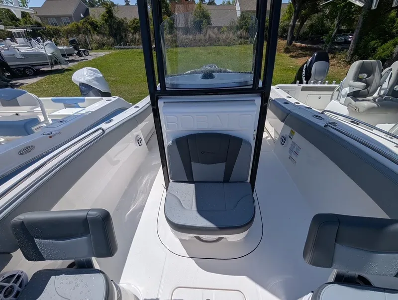 Slide: The Image of 2025 Robalo R232 Explorer boat interior with seating and console, parked outdoors. - 6