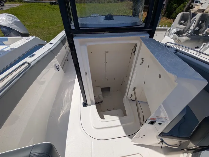 Slide: The Image of 2025 Robalo R232 Explorer boat interior storage compartment, open hatch view. - 8