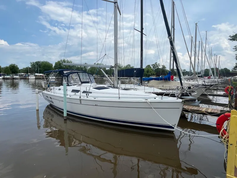 The Image of 2004 Hunter 41 sailboat docked at marina under blue sky. - 0