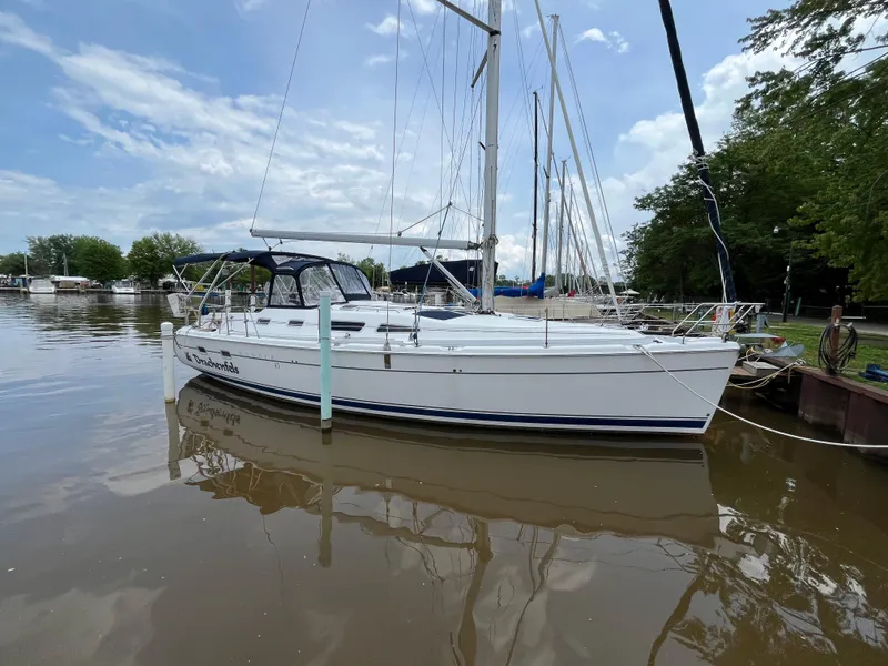 Slide: The Image of 2004 Hunter 41 sailboat docked on calm water under a partly cloudy sky. - 1