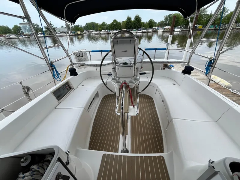 Slide: The Image of Cockpit of 2004 Hunter 41 sailboat with steering wheel, docked by calm waters. - 14