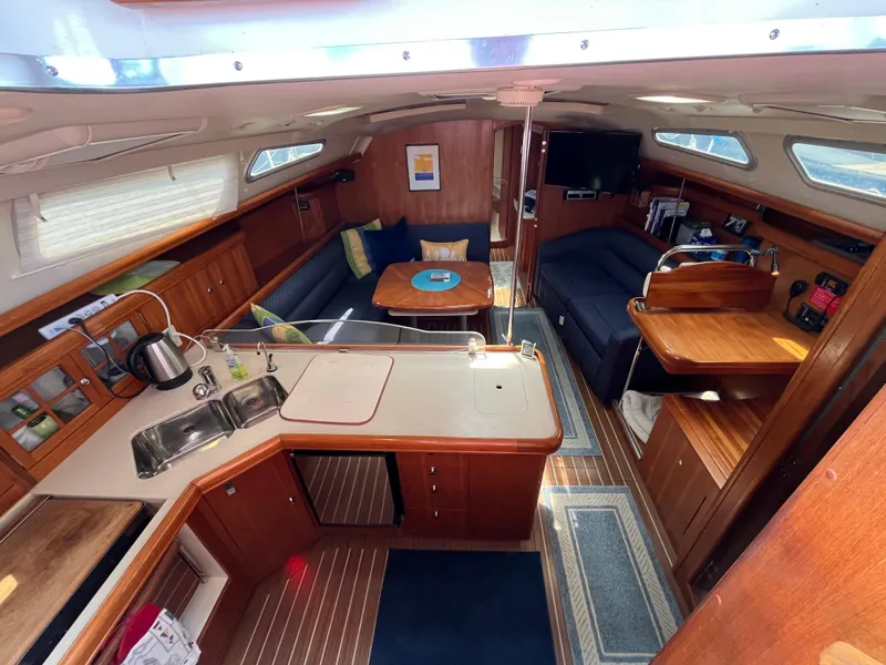 Slide: The Image of Interior of 2004 Hunter 41 sailboat with kitchen, seating, and wooden finishes. - 21