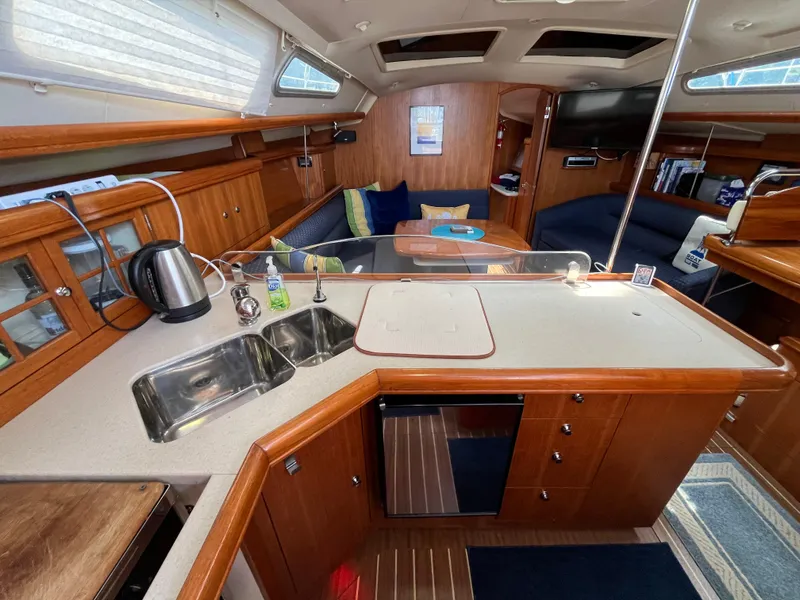 Slide: The Image of Interior of 2004 Hunter 41 sailboat with modern kitchen and cozy seating area. - 24