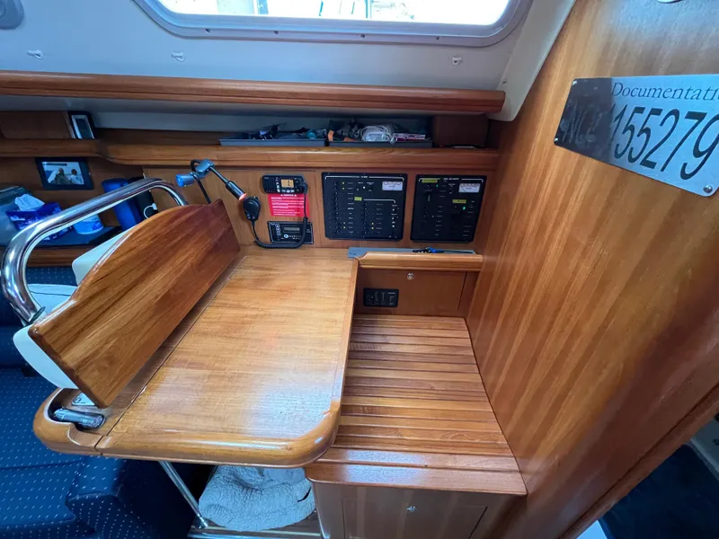 Slide: The Image of Navigation station on a 2004 Hunter 41 sailboat with control panels and wooden finish. - 27