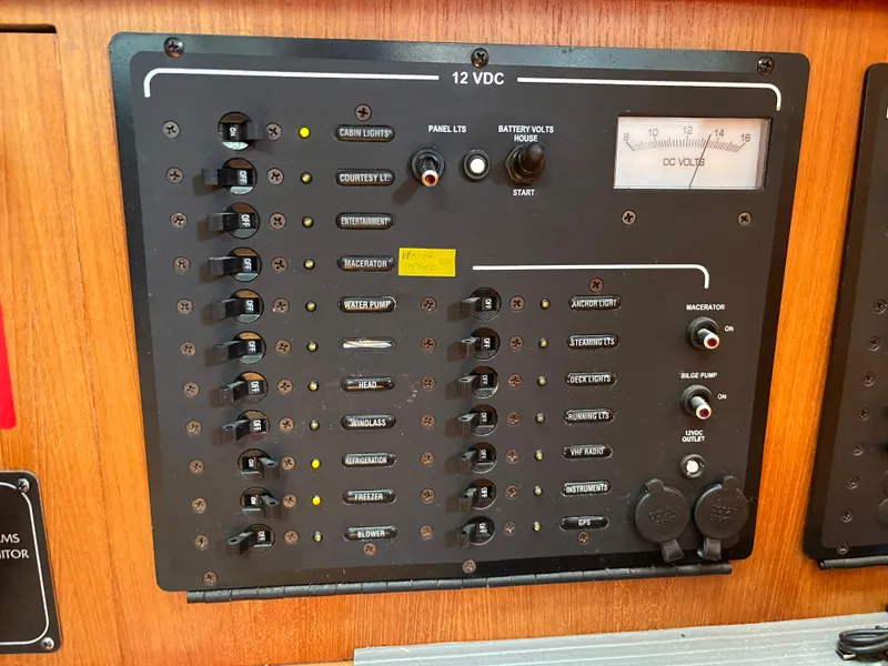 Slide: The Image of Electrical control panel on a 2004 Hunter 41 boat with various switches and voltmeter. - 28