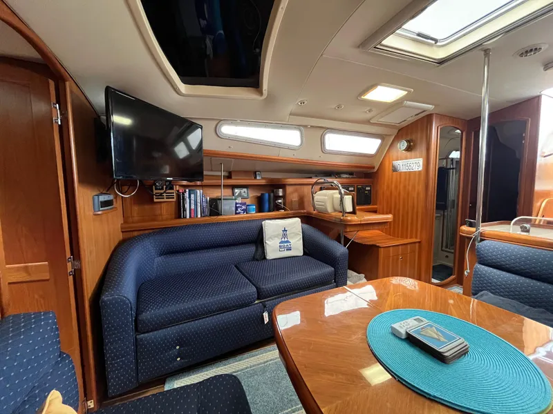 Slide: The Image of Interior of 2004 Hunter 41 yacht with blue seating, wooden finishes, and a mounted TV. - 39