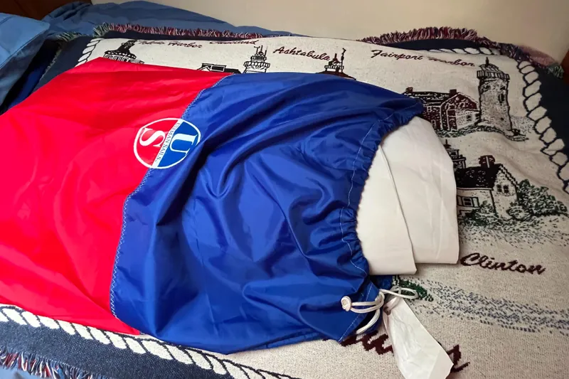 Slide: The Image of Red and blue sail bag on a nautical-themed blanket, Hunter 41 model, 2004. - 44