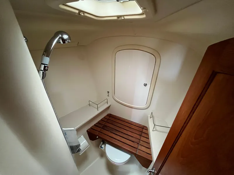 Slide: The Image of Compact bathroom in a 2004 Hunter 41 sailboat with shower and wooden seat. - 46