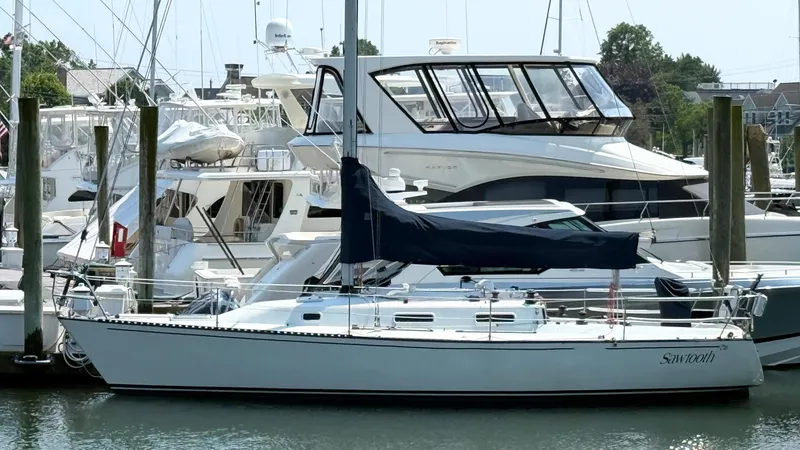 The Image of Sailboat Tartan Thomas 35, 1991 model, docked in a marina with other boats. - 0