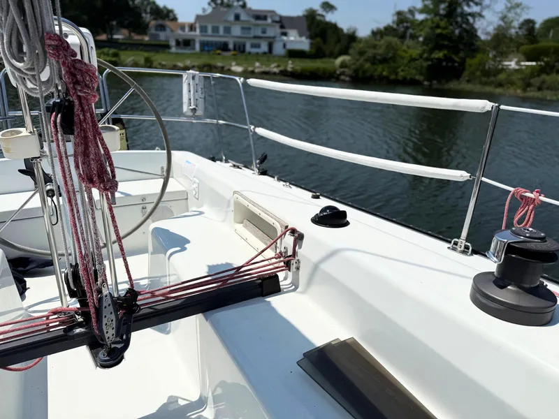 Slide: The Image of Sailboat deck of 1991 Tartan Thomas 35, featuring ropes and winches, near waterfront homes. - 12