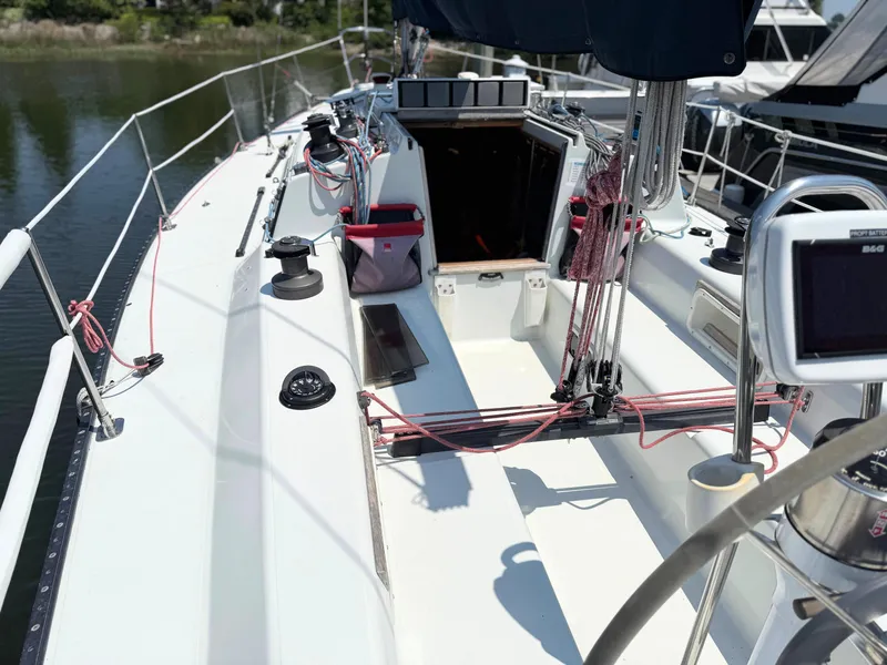 Slide: The Image of Sailboat deck of 1991 Tartan Thomas 35, featuring winches and ropes, docked by water. - 13