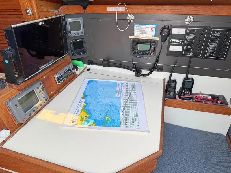 Slide: The Image of Navigation station on a 1991 Tartan Thomas 35 sailboat with electronic equipment and a nautical chart. - 19