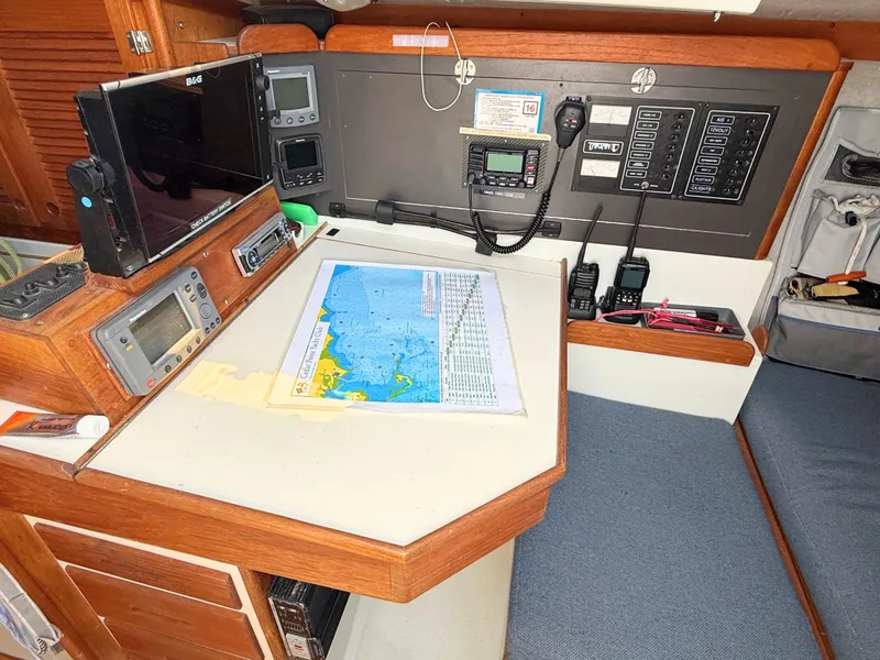 Slide: The Image of Navigation station on 1991 Tartan Thomas 35 sailboat with charts and electronic equipment. - 21