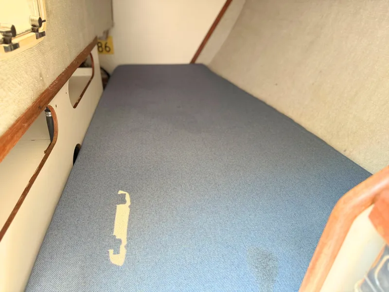 Slide: The Image of Interior of 1991 Tartan Thomas 35 sailboat with blue cushioned seating. - 25