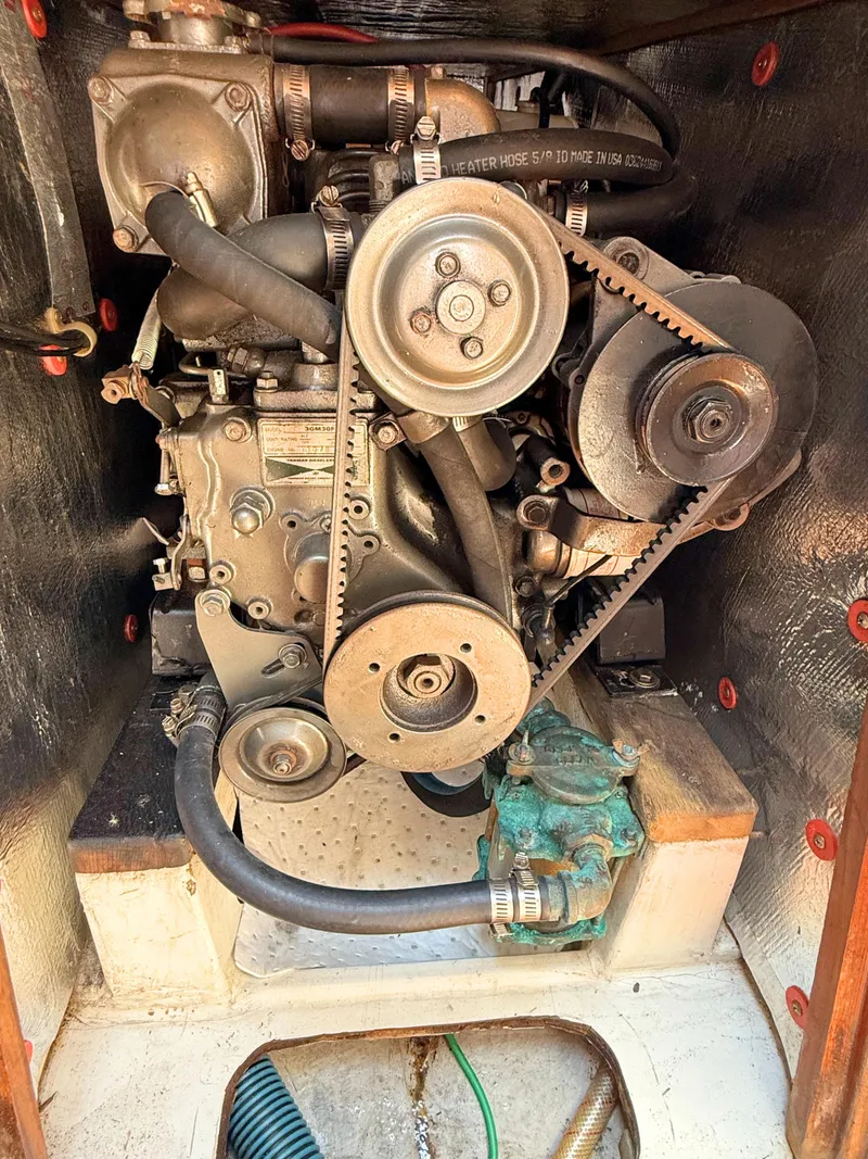 Slide: The Image of Engine compartment of a 1991 Tartan Thomas 35 sailboat, showcasing mechanical components and belts. - 26