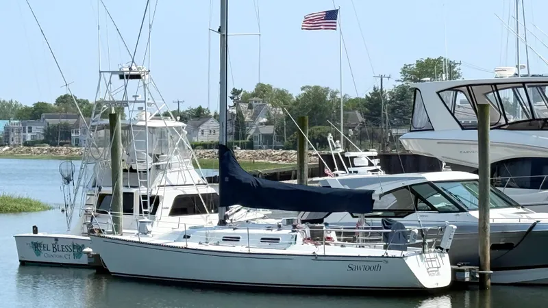 Slide: The Image of Sailboat Tartan Thomas 35, 1991 model, docked in marina with American flag. - 28