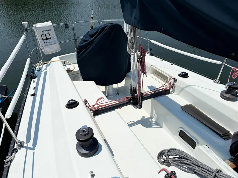 Slide: The Image of 1991 Tartan Thomas 35 sailboat deck with winches and ropes, docked on calm water. - 8