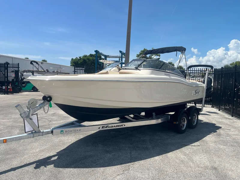 Slide: The Image of 2022 Scout 210 Dorado boat on trailer under clear blue sky. - 3