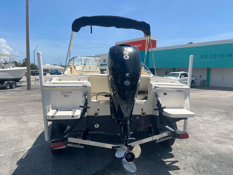 Slide: The Image of 2022 Scout 210 Dorado boat with outboard motor in a parking lot. - 5