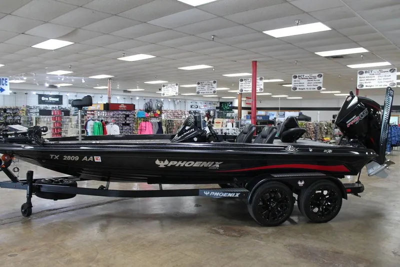 The Image of 2025 Phoenix 21 XE boat displayed in a showroom with fishing gear. - 0