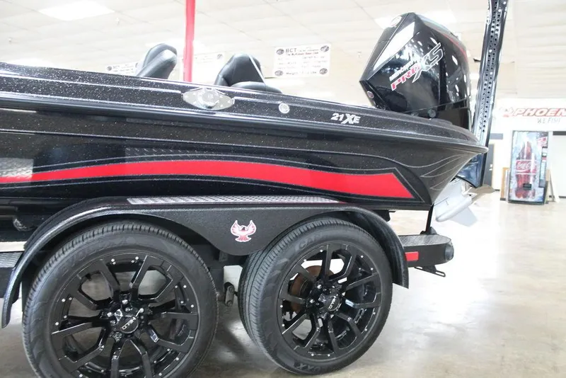 Slide: The Image of 2025 Phoenix 21 XE boat with black and red design, displayed indoors. - 10