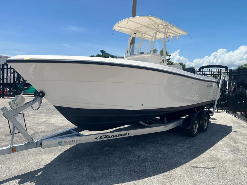 Slide: The Image of 2021 Cobia 237 Center Console boat on trailer under clear blue sky. - 3