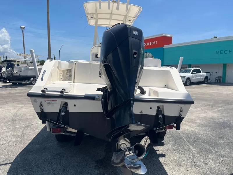 Slide: The Image of 2021 Cobia 237 Center Console boat with powerful outboard motor, parked outdoors. - 5