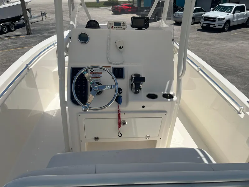 Slide: The Image of 2021 Cobia 237 Center Console boat helm with steering wheel and controls. - 6