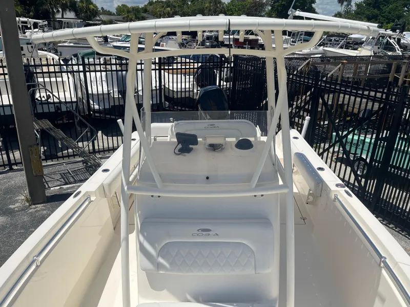 Slide: The Image of 2021 Cobia 237 Center Console boat with T-top, docked in a marina. - 9