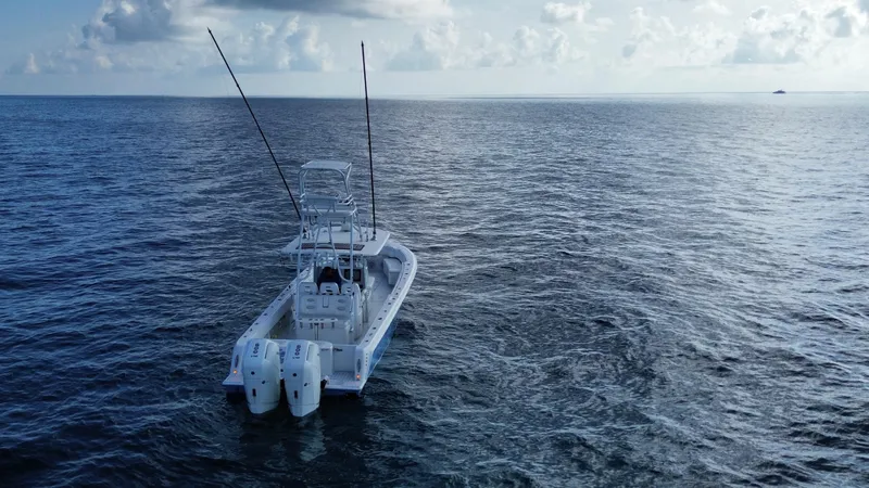 Slide: The Image of 2024 Contender 39 ST boat on open ocean, equipped with dual outboard engines. - 15