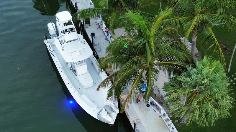 Slide: The Image of 2024 Contender 39 ST boat docked by palm trees, aerial view. - 2