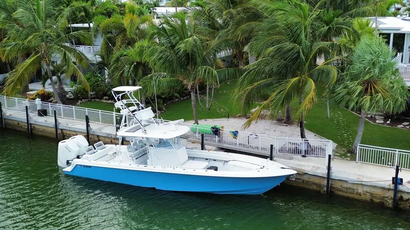 Slide: The Image of 2024 Contender 39 ST boat docked by tropical waterfront with palm trees. - 9
