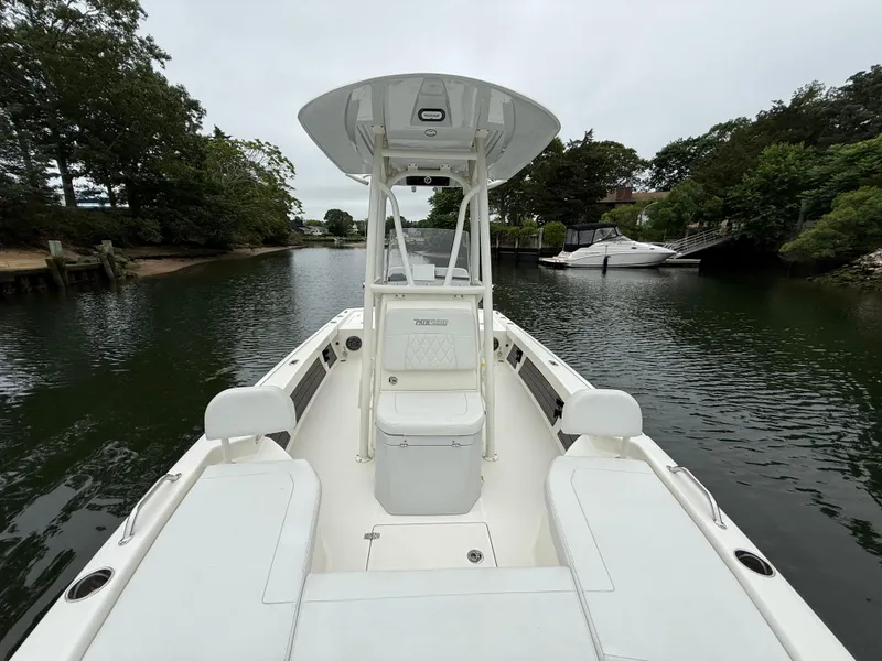 Slide: The Image of 2024 Pathfinder 2200 TRS boat on a calm river, surrounded by lush greenery. - 14