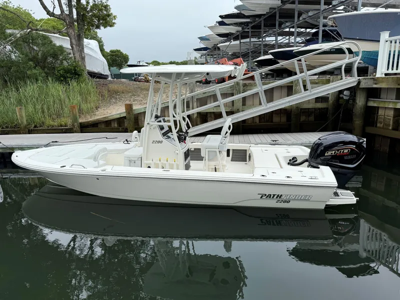 Slide: The Image of 2024 Pathfinder 2200 TRS boat docked, featuring sleek design and Yamaha engine. - 6
