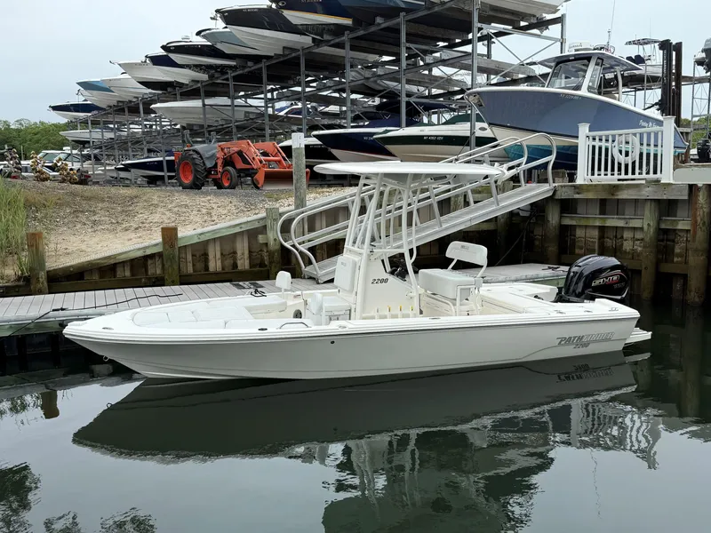Slide: The Image of 2024 Pathfinder 2200 TRS boat docked at marina with stacked boats in background. - 7