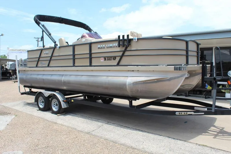 The Image of 2022 Massimo Marine P-23 TRITOON pontoon boat on trailer, parked outdoors. - 1
