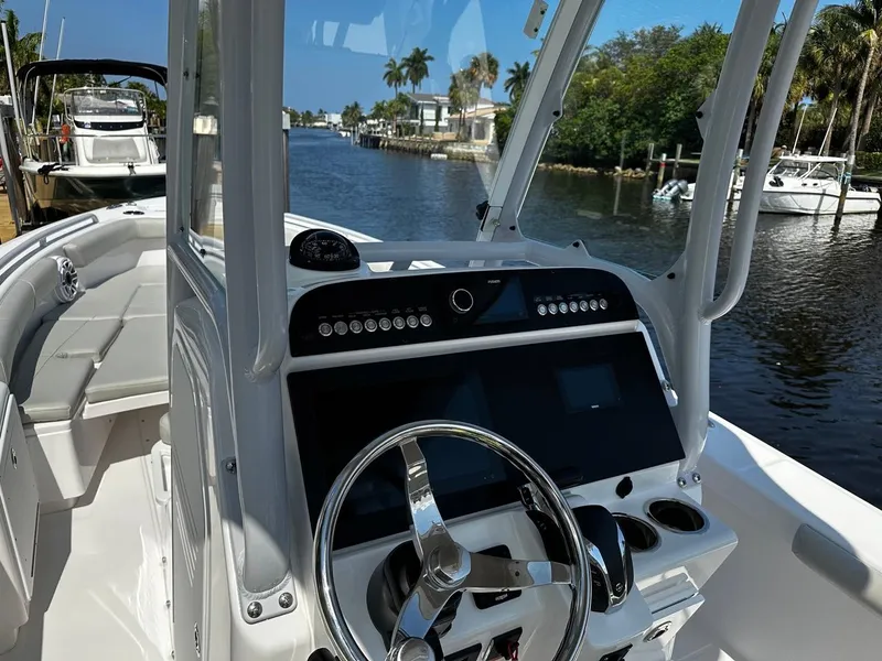 Slide: The Image of 2023 Everglades 243 Center Console boat interior with steering wheel and control panel. - 13