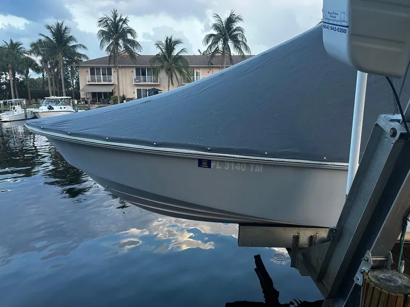 Slide: The Image of 2023 Everglades 243 Center Console boat covered and docked by waterfront homes. - 16