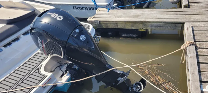 Slide: The Image of 2020 Bayliner VR5 Bowrider OB with outboard motor docked at a wooden pier. - 20
