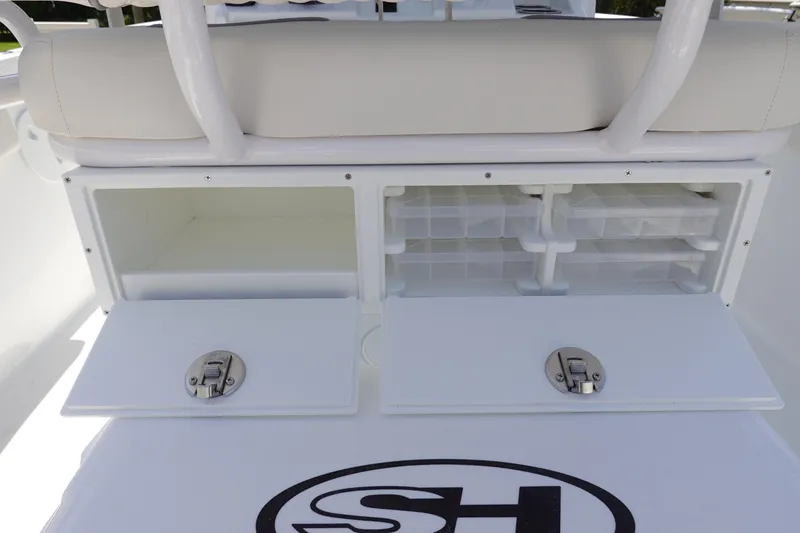 Slide: The Image of 2026 Sea Hunt Ultra 235 SE boat storage compartments with secure latches and organized trays. - 13