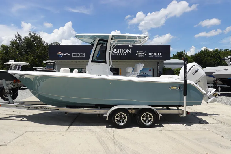 Slide: The Image of 2026 Sea Hunt Ultra 235 SE boat on trailer, displayed outdoors under a clear sky. - 2