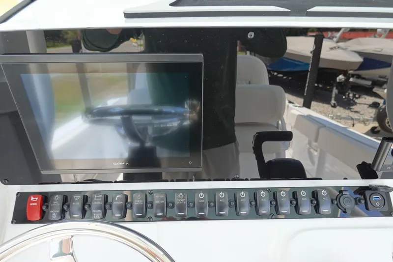 Slide: The Image of Control panel of 2026 Sea Hunt Ultra 235 SE boat with Garmin display and switches. - 23