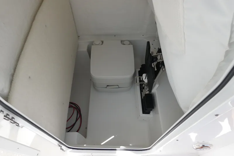 Slide: The Image of Interior of 2026 Sea Hunt Ultra 235 SE boat, featuring a compact marine toilet. - 35