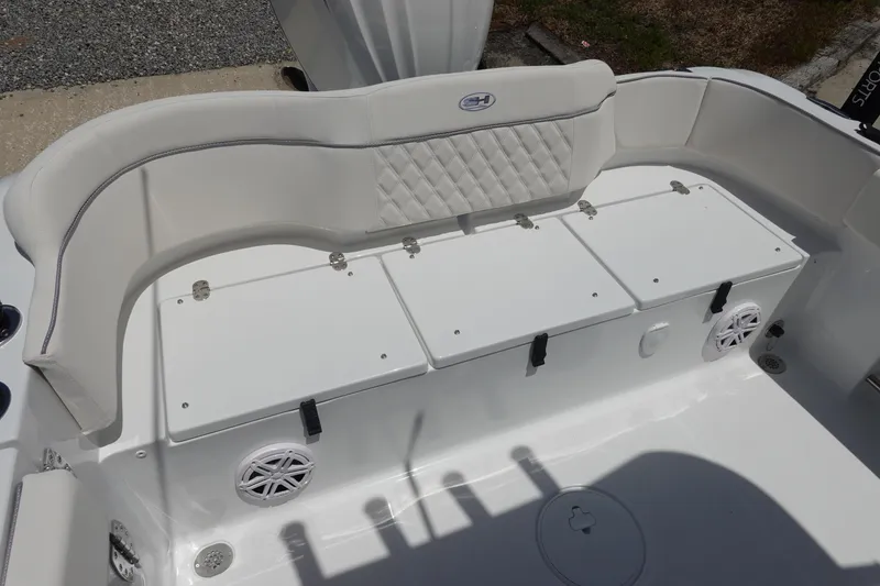 Slide: The Image of 2026 Sea Hunt Ultra 235 SE boat seating area with storage compartments and speakers. - 9