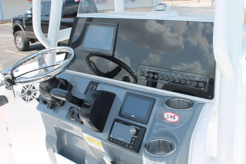 Slide: The Image of 2025 Tidewater 210 CC Adventure boat dashboard with steering wheel and electronic controls. - 11