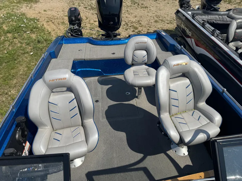 Slide: The Image of 2018 Nitro ZV21 boat interior with three gray seats and blue accents. - 15