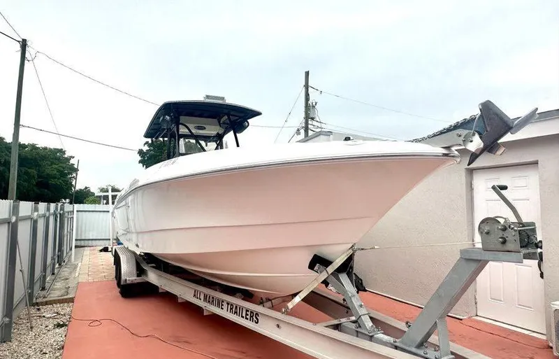 The Image of 2006 Wellcraft 32 CCF boat on trailer, parked outdoors. - 0