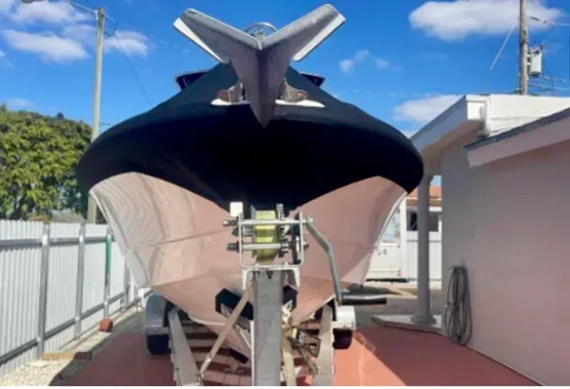 Slide: The Image of 2006 Wellcraft 32 CCF boat on trailer, parked outdoors under blue sky. - 2